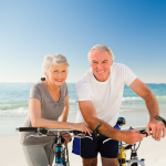 Retired couple with their bikes on the beach